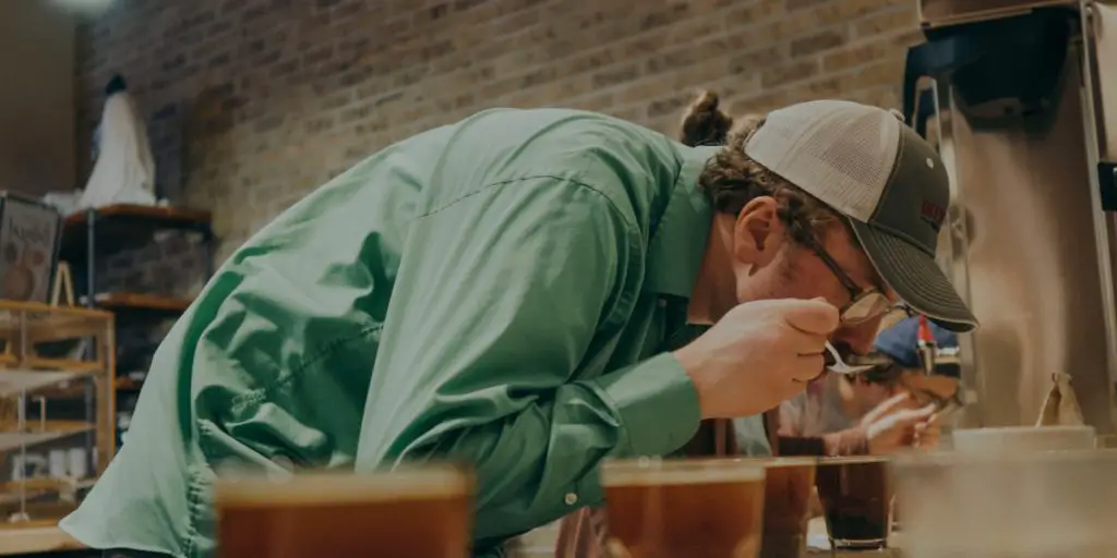 Man smelling different types of coffee during a coffee tasting.