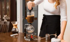 Woman testing and comparing a chemex coffee maker and bodum coffee maker.